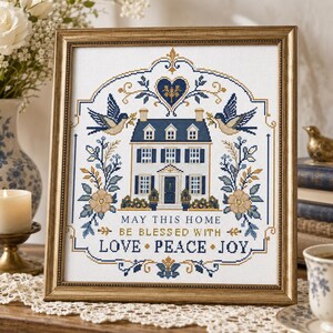 Puede incluir: Un bordado en punto de cruz enmarcado que presenta una ilustraci&oacute;n central de una casa rodeada de p&aacute;jaros, motivos florales y un coraz&oacute;n. El texto dice: MAY THIS HOME BE BLESSED WITH LOVE PEACE JOY. El dise&ntilde;o usa hilos azules, dorados y blancos.