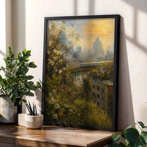 Könnte beinhalten: Ein gerahmter Kunstdruck, der eine Stadtsilhouette bei Sonnenuntergang mit einem Zug auf einer Brücke zeigt, umgeben von üppigem Grün und weißen Blumen im Vordergrund. Das Kunstwerk besticht durch warmes goldenes Licht und gedämpfte Erdtöne.