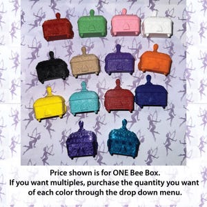 May include: A collection of small, decorative boxes in various colors, including red, green, pink, white, black, tan, purple, orange, yellow, turquoise, and blue. Each box has a hinged lid and a small handle. The text in the image says "Price shown is for ONE Bee Box."
