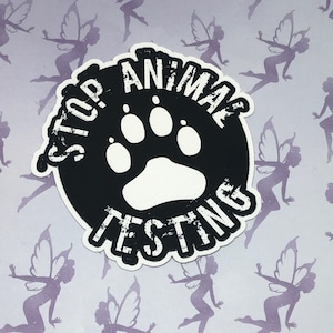 May include: Black and white sticker with the text "STOP ANIMAL TESTING" in a circle with a paw print in the center.