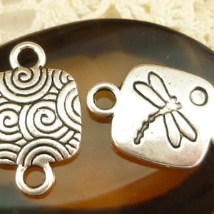 Puede incluir: Dos abalorios conectores de metal plateado, uno con un patrón de espiral y el otro con un diseño de libélula. Ambos abalorios tienen dos bucles para sujetar a joyas u otras manualidades.