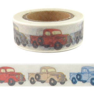 May include: A roll of washi tape with a repeating pattern of vintage pickup trucks in red, tan, and blue. The trucks are on a white background.