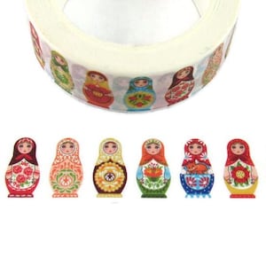 May include: Decorative washi tape featuring a repeating pattern of colorful Matryoshka dolls. The dolls are painted in various colors, including red, blue, green, and yellow, with floral and geometric designs. The tape is on a white background.