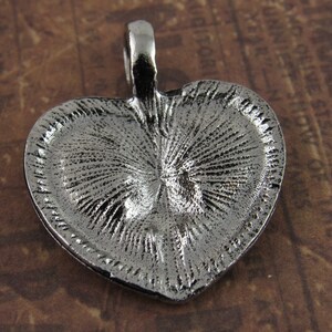Peut inclure: Pendentif en forme de c&oelig;ur en argent avec un design textur&eacute;. Le pendentif a une boucle en haut pour l'attacher &agrave; une cha&icirc;ne.
