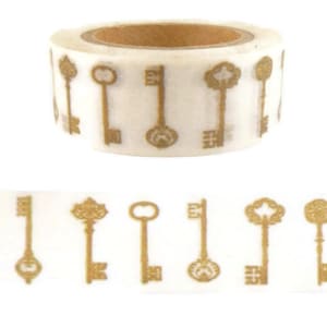 May include: A roll of gold key patterned washi tape. The tape is white with gold keys printed on it. The tape is rolled up and ready to be used.