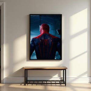 May include: A framed wall art print featuring a rear view of a character in a textured red and blue suit with a prominent red spider emblem on the back. The character is depicted against a dark, moody background with subtle blue lighting.