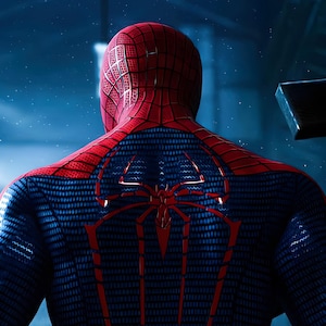 May include: A full-body suit featuring a red and blue color scheme with a textured web pattern. The back of the suit displays a large, prominent red spider emblem with long, downward-pointing legs that extend across the shoulder blades.