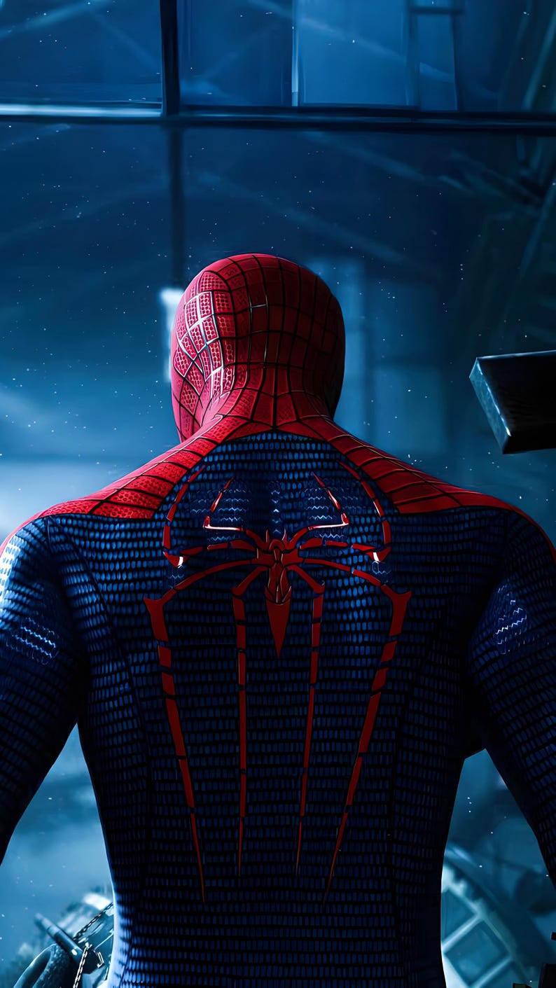 May include: A full-body suit featuring a red and blue color scheme with a textured web pattern. The back of the suit displays a large, prominent red spider emblem with long, downward-pointing legs that extend across the shoulder blades.