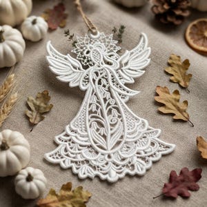 May include: A white lace angel ornament featuring intricate embroidery, a star-shaped halo, and a flared dress design with floral patterns. The ornament includes a small loop at the top for hanging and is crafted from detailed white thread work.