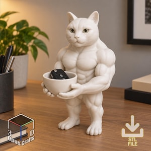 May include: A white, anthropomorphic cat figurine with a muscular, bodybuilder physique standing upright. The cat holds a small, matching white bowl in its hands, which contains a black car key fob. The figure has a smooth, matte finish.