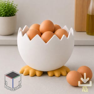 Può includere: Una ciotola bianca a forma di uovo con un bordo superiore frastagliato e piedini gialli, riempita con diverse uova marroni. La ciotola poggia su una superficie piana, con due uova marroni aggiuntive posizionate vicino. Un logo con il testo 3D Opus Crafts è visibile.