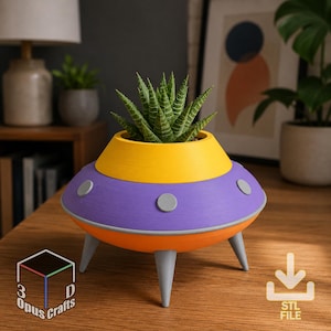 Op de afbeelding: Een UFO-vormige plantenbak met een gele bovenkant, een paars middengedeelte met grijze ronde accenten en een oranje basis op drie grijze poten. Een groene vetplant staat erin. De tekst 3D Opus Crafts en STL FILE zijn aanwezig.