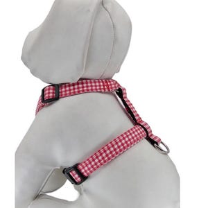 K&ouml;nnte beinhalten: Rotes und wei&szlig;es Gingham-Hundegeschirr mit schwarzer Hardware.