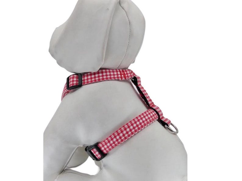 K&ouml;nnte beinhalten: Rotes und wei&szlig;es Gingham-Hundegeschirr mit schwarzer Hardware.