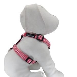 K&ouml;nnte beinhalten: Rotes und wei&szlig;es kariertes Hundegeschirr mit schwarzen verstellbaren Riemen und einem schwarzen Etikett mit der Aufschrift "Dog Wag Gear".