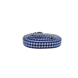 K&ouml;nnte beinhalten: Eine blaue und wei&szlig;e Gingham-Hundeleine, die mit einem silbernen Metallverschluss aufgerollt ist.