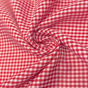 K&ouml;nnte beinhalten: Rotes und wei&szlig;es Gingham-Gewebe mit einem karierten Muster. Der Stoff ist gefaltet und drapiert und zeigt die Textur und die Webart.