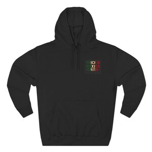 May include: A black hooded sweatshirt featuring a front kangaroo pocket and long sleeves. On the left chest, a rectangular graphic displays the text TRICK O MEXICO GRITA in stacked, alternating green, white, and red capital letters.