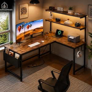 May include: An L-shaped computer desk with a dark wood grain surface and a black metal frame. It features two upper shelves with integrated lighting, a side storage pocket, two computer monitors, a keyboard, a mouse, a tablet, and a printer.