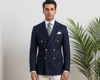 Traje de hombre formal de corte ajustado con blazer cruzado azul marino y pantalón blanco.