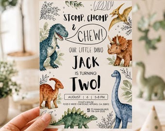 May include: A rectangular birthday invitation card featuring watercolor illustrations of various dinosaurs, including a T-Rex, Triceratops, and Stegosaurus. The text reads: STOMP, CHOMP & CHEW! OUR LITTLE DINO JACK IS TURNING TWO! AUGUST 6 5-8 PM COLE'S HOUSE.