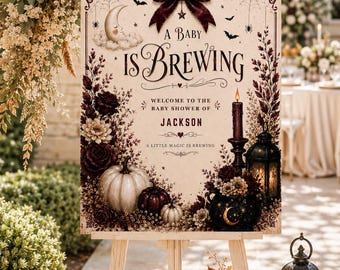 Könnte beinhalten: Ein rechteckiges Babyparty-Schild auf einer Holzstaffelei mit dem Text A BABY IS BREWING, WELCOME TO THE BABY SHOWER OF JACKSON und A LITTLE MAGIC IS BREWING. Das Design zeigt eine dunkle Schleife, einen Mond, Kürbisse, Blumen und eine Laterne.