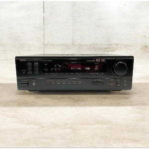 May include: A black Denon AV surround receiver model AVR-1604 featuring a central digital display showing the text VIRTUAL DVD. The front panel includes a large volume knob on the right, numerous control buttons, input selectors, and a headphone jack.