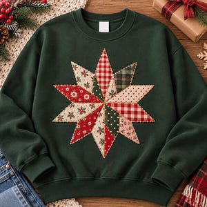 May include: A dark forest green crewneck sweatshirt featuring a large, central star-shaped applique. The star is constructed from various fabric patches in red, green, and cream, showcasing patterns like gingham, plaid, and floral motifs.