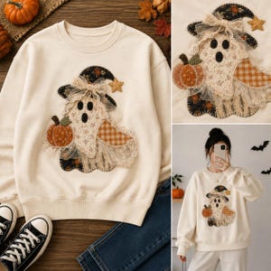 May include: A cream-colored crewneck sweatshirt featuring a large, multi-textured applique of a ghost wearing a witch hat. The ghost is decorated with lace, fabric patches in orange gingham and floral patterns, and a small orange pumpkin.