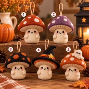 May include: Five felt mushroom ornaments with smiling faces and hanging loops. Number 1 is red with white spots, 2 is purple with white spots, 3 is black with orange spots, 4 wears a black witch hat with a yellow star, and 5 has a small white ghost.