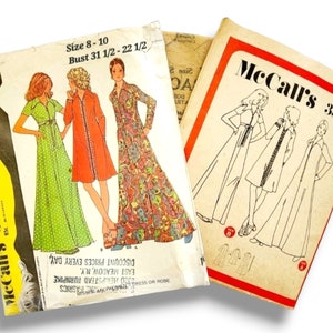May include: Vintage McCall's sewing patterns. The image shows three different pattern envelopes. The patterns feature illustrations of long dresses and robes. The text on the patterns includes the size, bust measurements, and the McCall's logo.