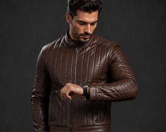 May include: A dark brown leather jacket featuring vertical quilted stitching, a stand-up collar with a snap button closure, and a full-length front zipper. The jacket has long sleeves and a fitted silhouette, providing a structured appearance.