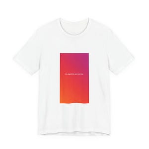 May include: A white short-sleeved t-shirt featuring a rectangular graphic on the chest. The graphic displays a vertical gradient transitioning from purple to red to orange, with the white text "my algorithm sent me here" centered.