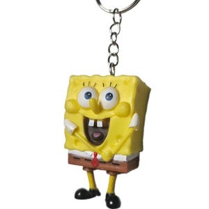 Op de afbeelding: Een gele, rechthoekige SpongeBob SquarePants-sleutelhanger met een lachend gezicht, blauwe ogen, twee witte tanden en een rode das. Het figuurtje heeft dunne gele armen en benen met zwarte schoenen en zit vast aan een zilverkleurige metalen ring.