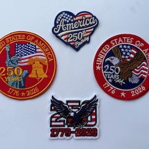 May include: Four embroidered patches celebrating the 250th anniversary of the United States. Designs include a heart shape, two circular patches with the Statue of Liberty or a bald eagle, and a rectangular patch featuring a bald eagle and 1776-2026.