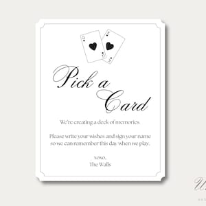 K&ouml;nnte beinhalten: Ein wei&szlig;es rechteckiges Schild mit schwarzem Rand, das oben zwei Spielkarten zeigt, eine Herz-Dame und einen Herz-K&ouml;nig. Der Text lautet: Pick a Card, We're creating a deck of memories. Please write your wishes and sign your name so we can remember this day when we play. XOXO, The Walls.