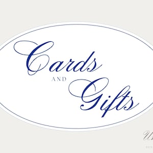 May include: An oval-shaped sign with a white background and a thin blue border. The text "Cards AND Gifts" is printed in the center in a dark blue, elegant script font. In the bottom right corner, the text "Union DESIGN HOUSE" appears in gray.