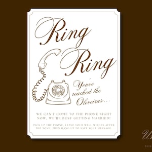 May include: A rectangular white sign with brown text and a line drawing of a rotary telephone. The text reads: Ring Ring, You've reached the Oliveiras... WE CAN'T COME TO THE PHONE RIGHT NOW, WE'RE BUSY GETTING MARRIED! PICK UP THE PHONE, LEAVE YOUR WELL WISHES AFTER THE TONE, THEN HANG UP TO SAVE YOUR MESSAGE.