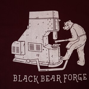 Bear working with power hammer. Black Bear Forge Tee shirt image 2