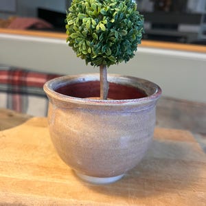 Op de afbeelding: Een witte keramische mok met een zwart handvat en de tekst "But First, Coffee" in een zwarte, vette letter. De mok staat op een wit oppervlak. De mok is ongeveer 10 cm hoog.