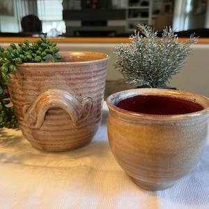 May include: A set of three ceramic mugs with a speckled, matte finish. Each mug features a different color: light blue, cream, and gray. The mugs have a simple, modern design and a comfortable handle.