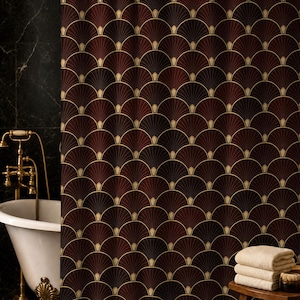May include: A shower curtain featuring a repeating fan-shaped pattern in deep burgundy and black with gold-toned outlines. The curtain hangs from a gold-toned rod and displays a symmetrical, geometric design across its entire surface area.