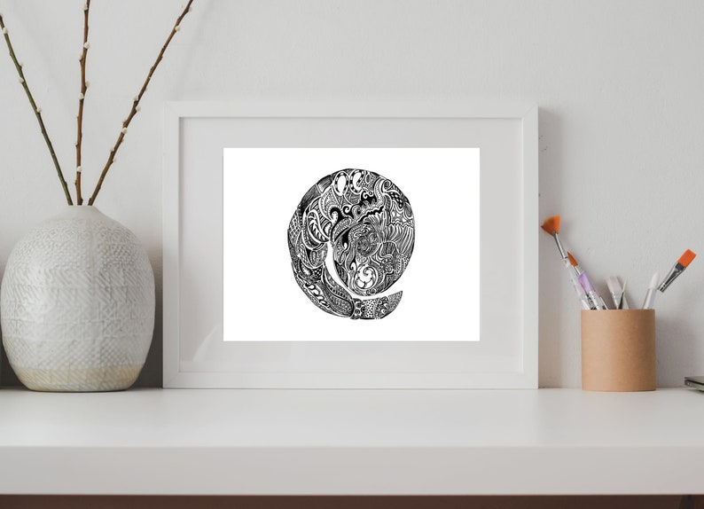 May include: A black and white framed print of a circular design with intricate details. The design is reminiscent of a spiral or a swirling pattern.