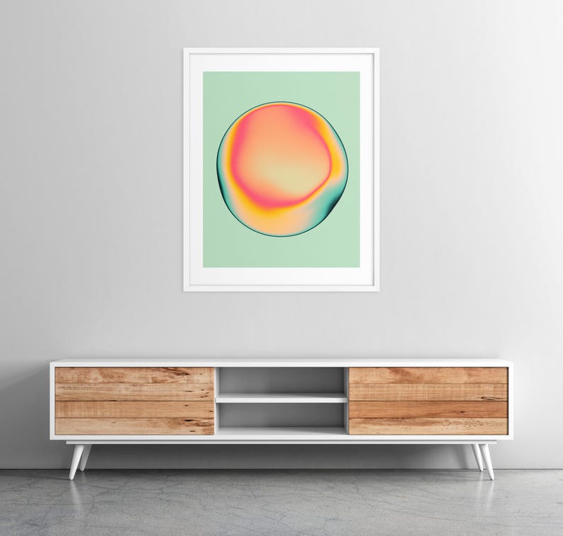 a modern, minimalist living room with a white entertainment center and a framed abstract art piece hanging on the wall above it.