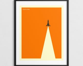 Puede incluir: Impresión artística enmarcada con un diseño minimalista de un cohete negro ascendiendo sobre un fondo naranja. Una estela blanca se extiende desde el cohete, y la palabra "EXPLORE" está impresa en la parte superior. La obra está enmarcada en un marco negro.