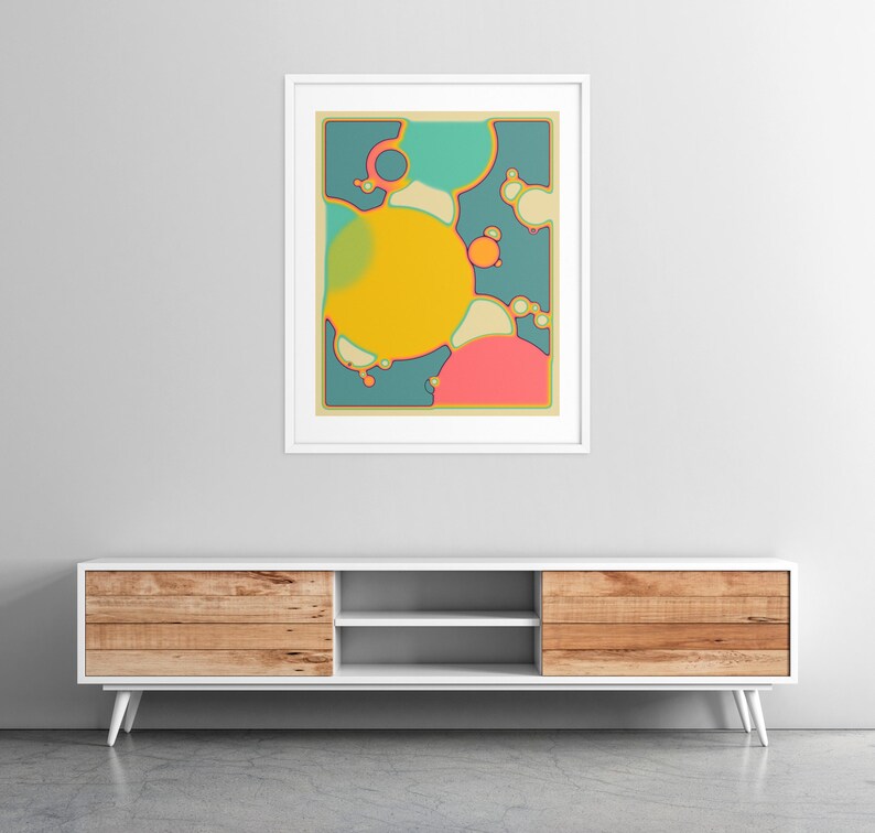 a modern, minimalist living room setting with a white entertainment center and a framed abstract art piece hanging on the wall above it.