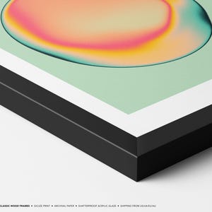 The image is a framed artwork featuring a vibrant abstract design with a gradient of colors, including pink, orange, and green, against a white background.