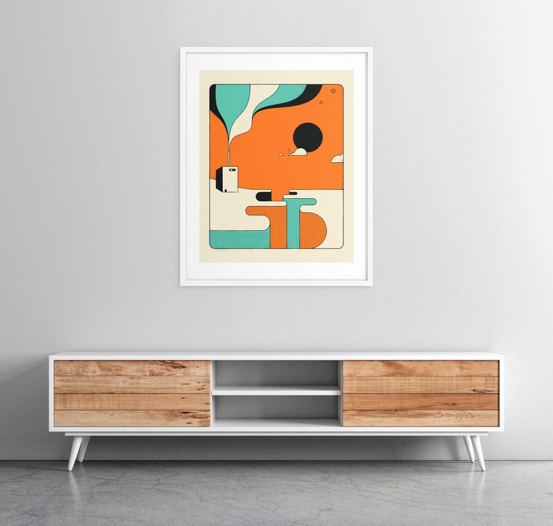a modern, minimalist living room with a white entertainment center and a framed abstract art piece hanging on the wall above it.