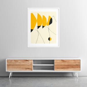 a minimalist design with a white entertainment unit against a gray wall, and a framed abstract art piece above it.