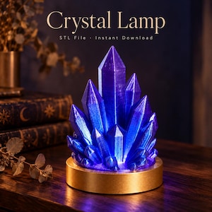 Peut inclure: Une lampe cristal violette composée d'un amas de structures cristallines pointues et translucides éclairées de l'intérieur, posée sur une base circulaire dorée. Le texte Crystal Lamp STL File Instant Download est visible.